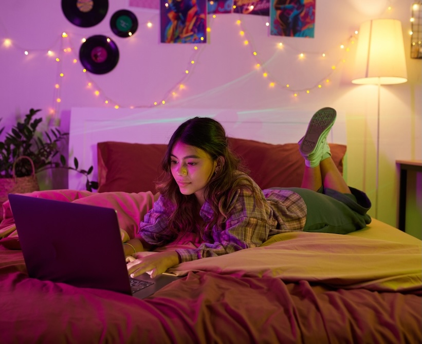 Teen with headphones writing in journal
